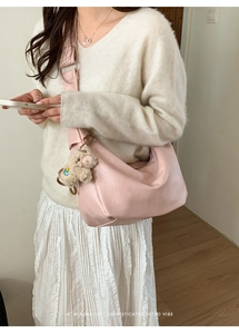 Pink leather hobo bag with a soft cream alpaca plush keychain and wide shoulder strap