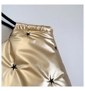 Close-up of quilted gold fabric with black star embroidery and metallic puffy texture