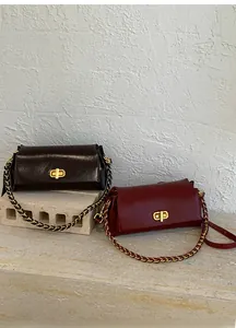 Detail of vintage leather crossbody bags with gold rotating locks and chain straps