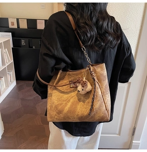 Détail du grand sac cabas en daim marron avec motif ours gaufré et breloque en peluche