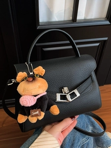 Elegant black lychee leather handbag with silver clasp and cute puppy charm accessory