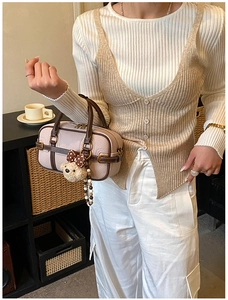 Détail d'un sac baguette chic avec charm ours et bandoulière en perles colorées