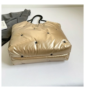Champagne gold quilted tote bag with black star embroidery and sleek black top handles