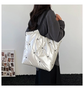 Detail of silver quilted tote bag with black star prints shown in a lifestyle shot