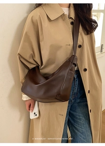 Model wearing dark brown retro dumpling bag with knot strap and soft leather texture
