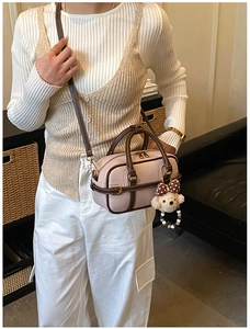 Détail du sac Boston rose et marron avec un joli pendentif chien en peluche blanche