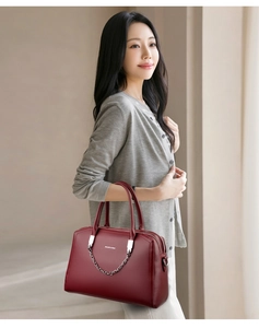 Détail du sac en cuir bordeaux avec chaîne argentée et fermeture à glissière double