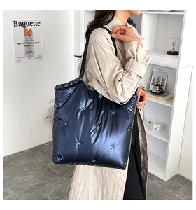 Detailed close-up of dark blue quilted tote bag with star embroidery on nylon fabric