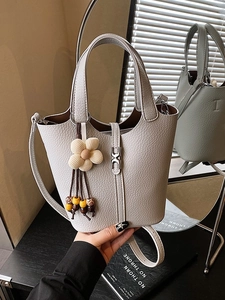 Chic light gray litchi texture bucket bag with floral charm and shoulder strap