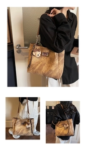 Detail view of large brown vintage tote bag with plush bear charm and retro texture