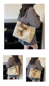 Detail of beige tote bag with embossed bear texture and brown leather straps