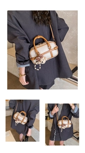 Détail des coutures, fermetures et charm ours sur un sac baguette en cuir beige