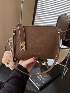 Dark brown pebbled leather crossbody bag with gold twist lock and cute plush bear charm
