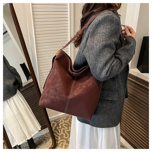Close-up of deep brown vintage hobo tote bag with white contrast stitching details