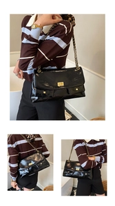 Detail of quilted black tote with gold chain strap and textured leather finish