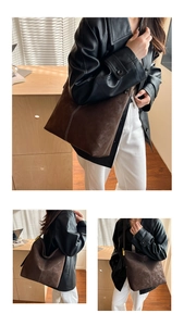 Detail of dark brown suede tote bag with white contrast stitching and soft texture