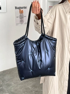 Large shiny black star-quilted tote bag for women featuring versatile shoulder straps