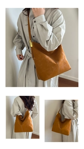 Detailed macro view of caramel tote bag featuring white stitching and gold metal buckle