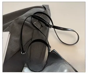 Close-up of silver bucket bag with adjustable black leather strap and metal eyelets