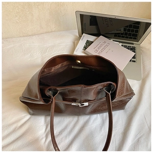 Detailed view of dark brown oil wax leather tote bag with glossy finish and thin straps