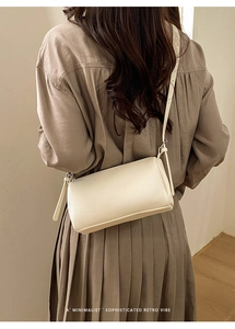 Detail of cream pillow bag showing lychee grain leather and silver metal buckles