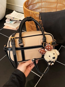 Sac baguette Boston en cuir grainé beige et noir avec breloque chien et détails dorés
