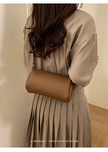 Minimalist caramel lychee grain leather shoulder bag shown in a retro lifestyle setting