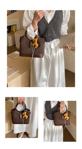Close-up of retro brown tote bag featuring mixed textures and yellow horse charm detail