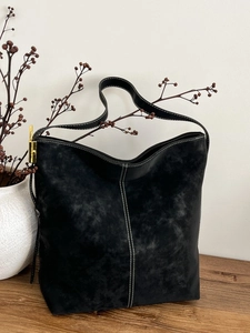 Minimalist black tote bag in matte leather with white contrast stitching and gold buckle