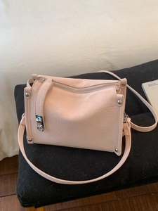 Pink minimalist crossbody baguette bag with silver rivets and textured leather finish