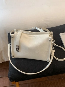 Chic cream-colored baguette shoulder bag with silver hardware and pleated leather texture