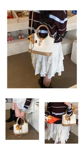 Detail of cream and brown tote bag with yellow pony charm and zebra ribbon decoration