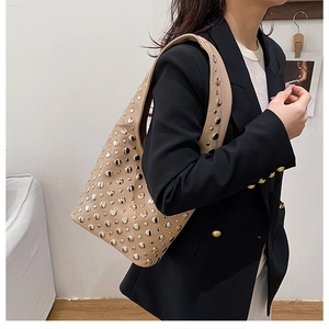 Détail du sac hobo beige orné de rivets métalliques argentés au style punk et tendance