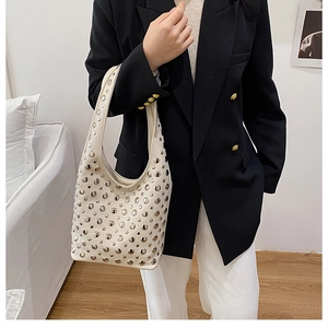 Détail du sac à bandoulière en similicuir blanc cassé avec des rivets en métal argenté