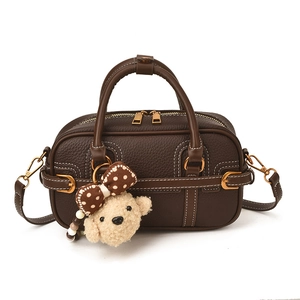 Borsa vintage in pelle marrone con cuciture bianche e ciondolo a forma di barboncino