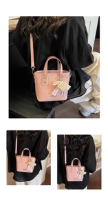 Borsa a secchiello in vernice rosa con ciondolo a perla e fiocco indossata da modella