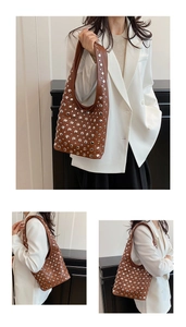 Macro view of a brown vintage hobo bag featuring decorative silver metal rivets and matte finish