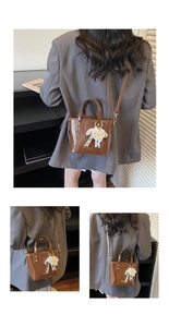Dettaglio mini borsa a secchiello marrone in pelle lucida con elegante ciondolo in pizzo e perle
