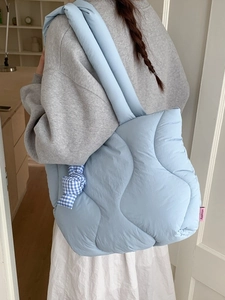 Light blue quilted puffer shoulder bag with wave stitching and checkered bow accessory