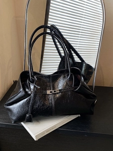 Minimalist black shiny leather tote bag with silver buckle and dual shoulder straps