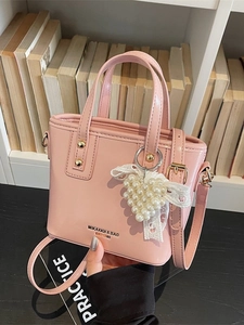 Rosa Mini-Eimertasche aus Lackleder mit Perlenherz-Anhänger und Schleifendetail