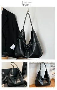 Detail of black hobo bag with silver metal eyelets and smooth synthetic leather finish