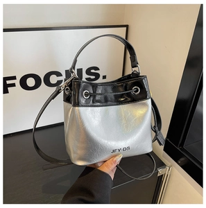 Detail of contrast bucket bag with black and silver texture and branded JFY·DS logo