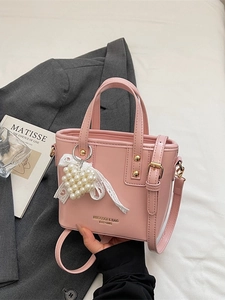 Rosafarbene Lackleder Eimertasche mit Herz-Perlenanhänger und Schleife im schicken Stil