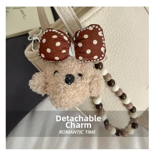 Detail of a detachable plush bear charm with polka dot bow and beaded strap for handbags