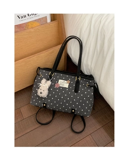 Detailed texture of charcoal polka dot tote bag with cute dog patch and plush bunny charm