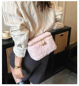 Detailed view of pink plush mini box bag featuring gold dice charms and chain strap