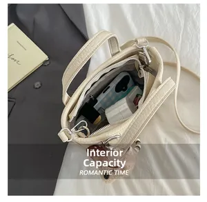 Internal capacity of the beige bucket bag showing phone, lipstick, and makeup items