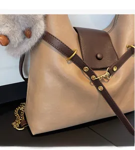 Detail of soft textured leather tote bag with gold hardware and plush charm pendant