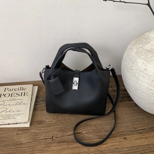 Close-up of black litchi grain leather bucket bag with silver metal swivel lock